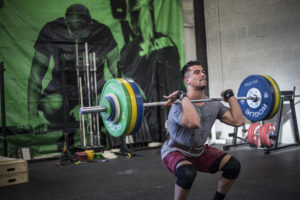 Male athlete at the bottom of a heavy front squat.