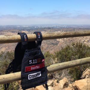 An Invictus weighted vest hanging on a fence at the top of a mountain.