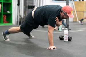 Male masters athlete doing plank shoulder taps.