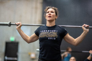 Female athlete doing a barbell warm-up.