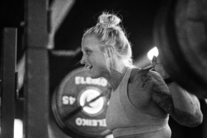 Female Invictus Athlete at the top of a back squat.