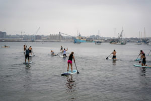 Group of athletes stand-up paddle boarding at the beach.