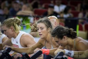 Female athletes riding the Assault Bike at CrossFit Semifinals.