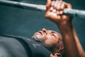 Close up of male athlete doing a bench press.