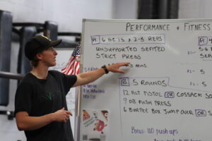 Coach Kirsten going over the WOD at the whiteboard.