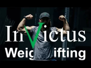 Coach Jared in front of an Invictus Weightlifting logo
